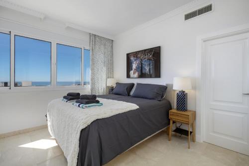 a bedroom with a large bed and large windows at Villa La Perla by Finest Rentals in Marbella