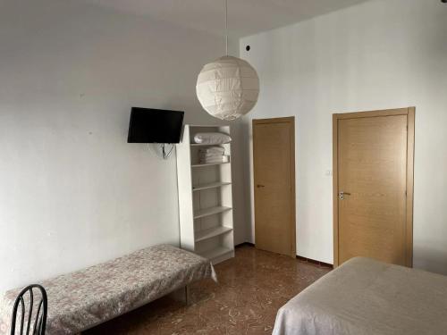 une chambre avec un banc, une télévision et une lampe dans l'établissement Fonda Joan, à Santa Coloma de Farners