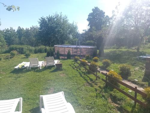 a yard with two chairs and a fence at Вила Нина в Крамолин in Kramolin