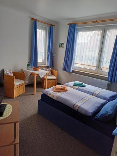 a bedroom with a large bed and a table at Pension Abendsonne in Büsum