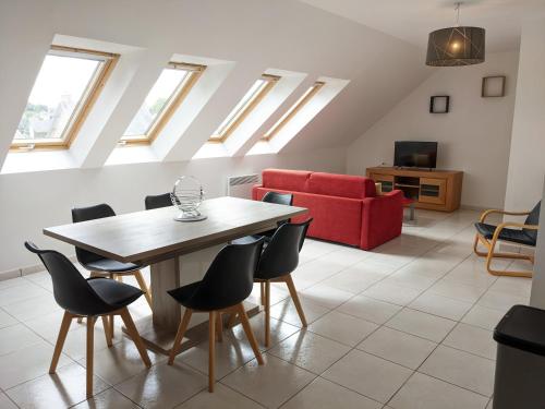 un salon avec une table et un canapé rouge dans l'établissement T2 lumineux à Perros-Guirec, plein centre-ville, à Perros-Guirec