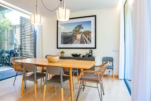 a dining room with a wooden table and chairs at Home Six Troia in Carvalhal