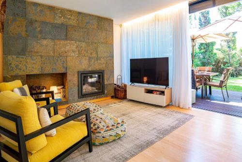 a living room with a fireplace and a tv at Home Six Troia in Carvalhal