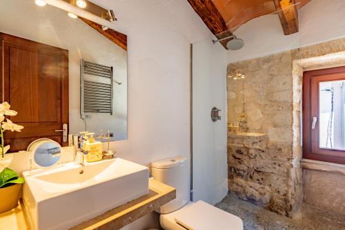 a white bathroom with a sink and a toilet at Albuqassim a modern townhouse in Pollensa, with heated pool in Pollença