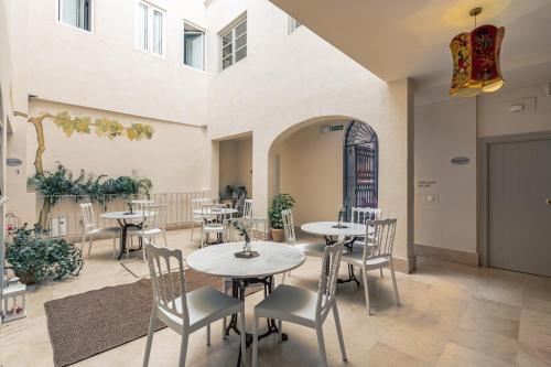un restaurante con mesas y sillas en una habitación en Santacruz Hostal Plaza, en Sevilla