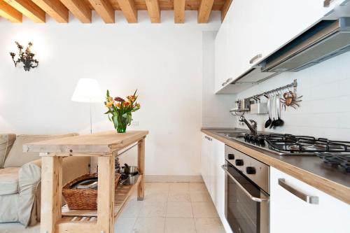 cocina con paredes blancas y mesa de madera en Guglie Luxury Apartment, en Venecia