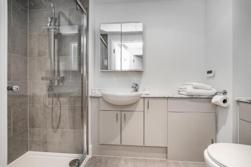 a white bathroom with a shower and a sink at Citystay Living - Dutch's Corner in Cambridge