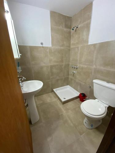 a bathroom with a white toilet and a sink at Duplex nuevo Playa Unión in Playa Unión