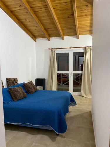 a bedroom with a blue bed and a window at Duplex nuevo Playa Unión in Playa Unión