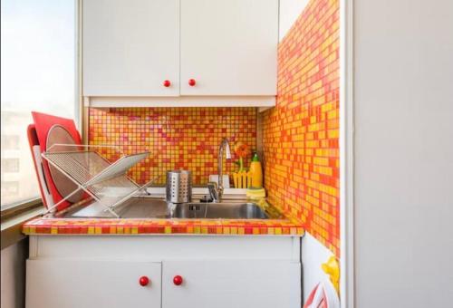 cocina con fregadero y pared de azulejos en Meraviglioso Attico con Terrazza Panoramica en Roma