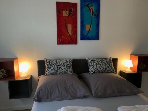 łóżko z dwoma lampami i dwoma obrazami na ścianie w obiekcie Haus Am Damm w mieście Kleve