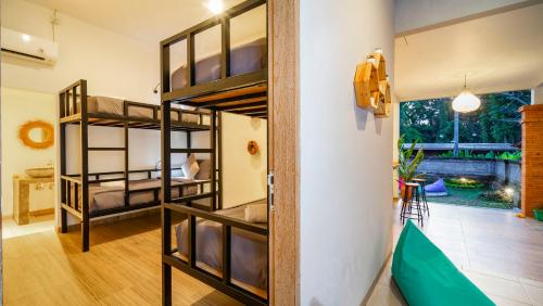 a room with two bunk beds and a doorway at Aura Dormitory House Ubud in Ubud
