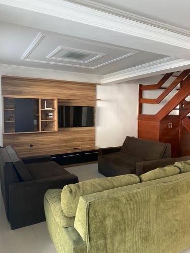 a living room with a couch and a tv at Pousada Arraial Beach in Arraial do Cabo
