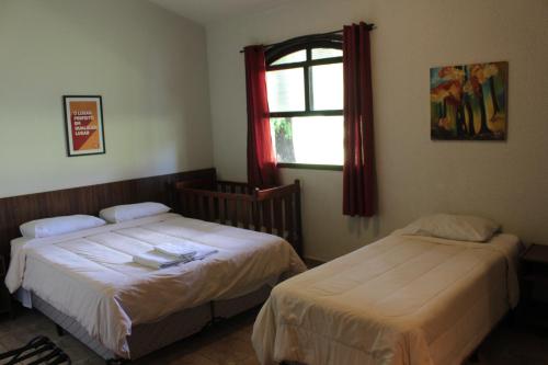 a bedroom with two beds and a window at Itaygua Hotel in Ribeirão Preto