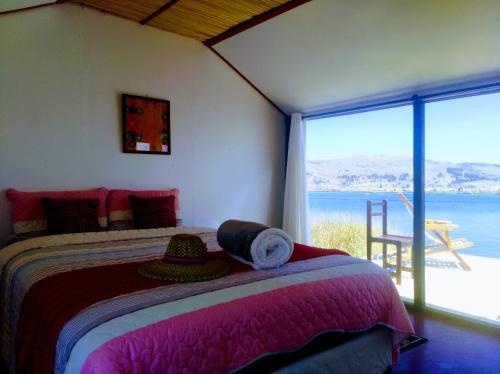a bedroom with a bed with a view of the ocean at Titicaca wasy lodge in Puno