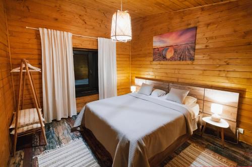 a bedroom with a bed in a wooden wall at Shurra in Buzău