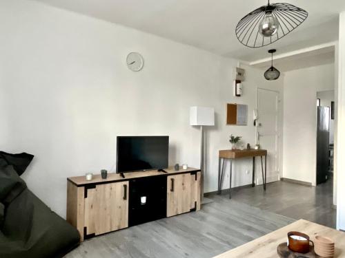 ein Wohnzimmer mit einem Flachbild-TV auf einem Schrank in der Unterkunft Appartement lumineux et traversant in Montauban