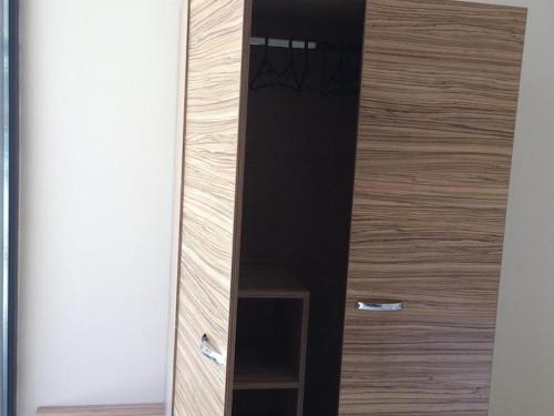 a wooden cabinet with a mirror in a room at Hotel Tm Deluxe located in Sunny Beach in Sunny Beach