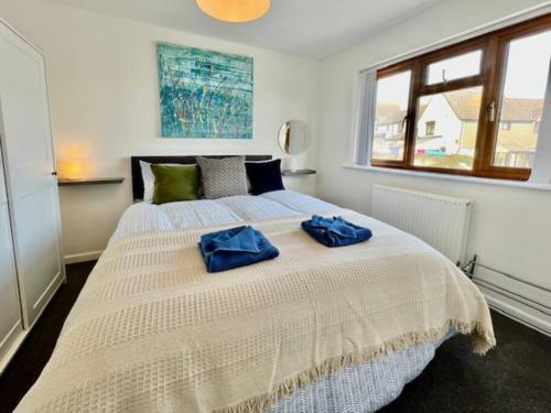 una camera da letto con un letto con due asciugamani blu sopra di Paddy Whack -A short stroll to Brixham Harbour a Brixham