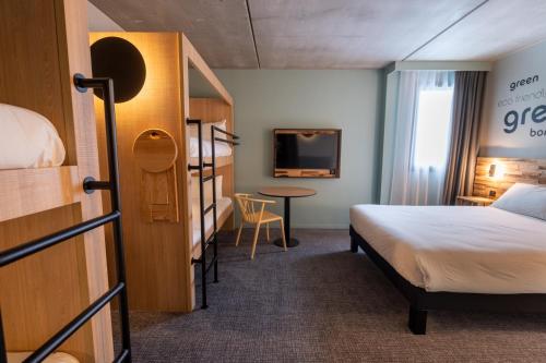 a hotel room with a bed and a desk at Greet Hôtel Orthez Bearn in Orthez