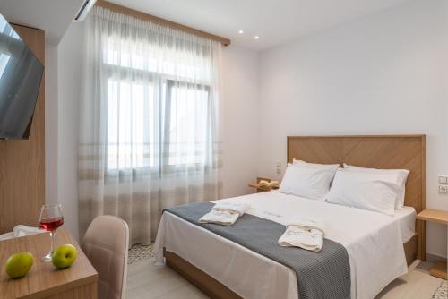 a bedroom with a bed and a glass of wine at Horizon Ionian Villas in Perdika