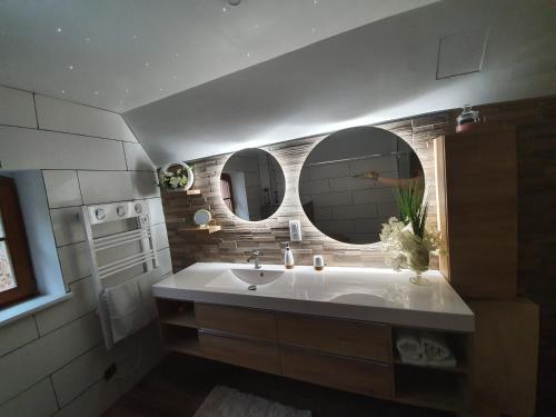 a bathroom with a sink and two mirrors at Gite des écureuils in Obernai