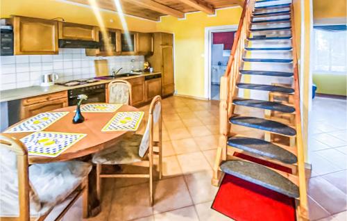 cocina con mesa y escalera de caracol en una habitación en Gorgeous Home In Kamionki Male, en Kamionki Małe