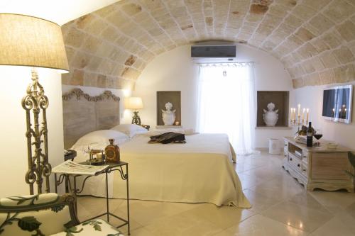 a bedroom with a large bed and a stone wall at Hotel Don Ferrante in Monopoli