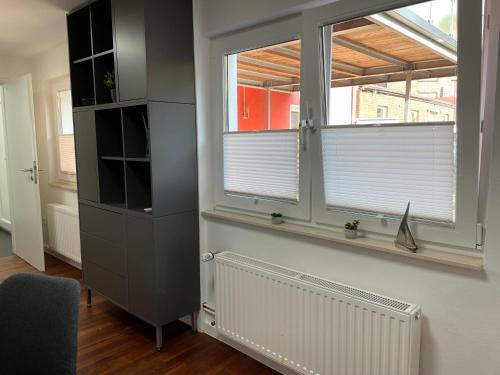 uma sala de estar com uma janela e um radiador em Studio em Wilhelmshaven
