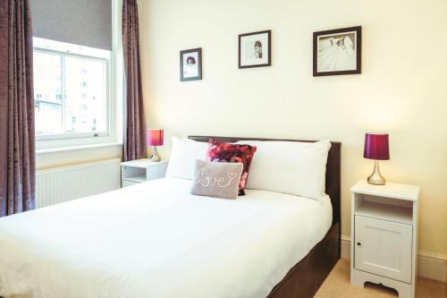 a bedroom with a bed with white sheets and a window at Stylish, central, adults-only 1-bed Hideaway in Eastbourne