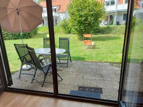 a patio with a table and chairs and an umbrella at Ferien­wohnung Baumann in Pleinfeld