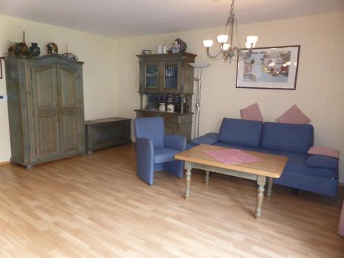 sala de estar con sofá azul y mesa en Ferien­wohnung Baumann, en Pleinfeld