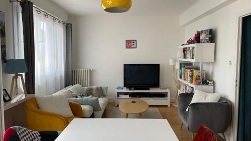 a living room with a couch and a tv at Maison entière au calme à Saint-Max/Nancy in Saint-Max