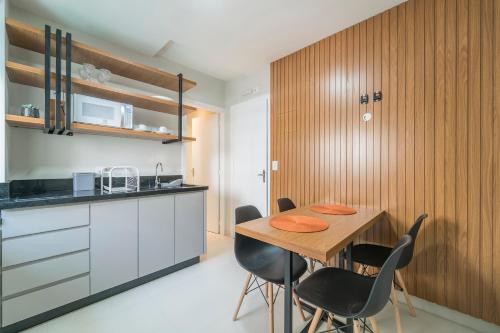 uma cozinha e sala de jantar com mesa e cadeiras em Residencial Bombinhas em Bombinhas