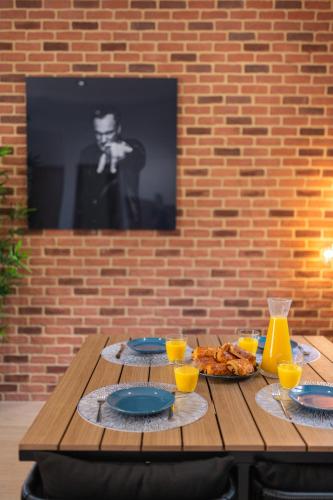a wooden table with plates of food and drinks on it at SUPERBE APPARTEMENT AVEC BALCON PROCHE MONACO in Beausoleil