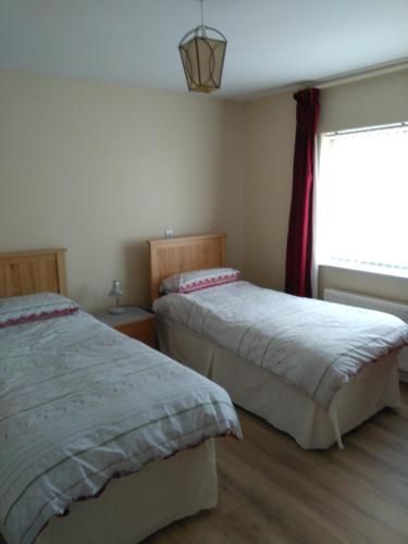 a bedroom with two beds and a window at The Tardis, Portstewart Town in Portstewart
