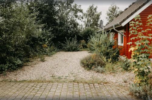 a garden in front of a red house at Haus Hanni Zarrentin am Schaalsee in Zarrentin