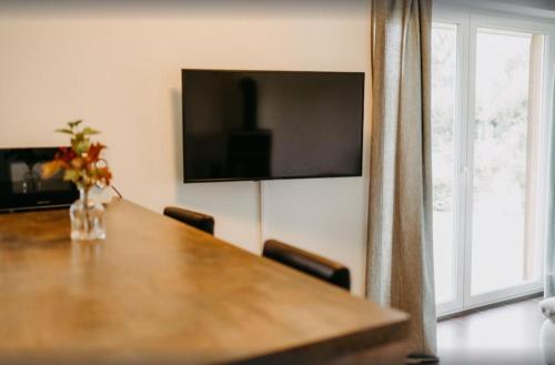 a dining room table with chairs and a television on the wall at Haus Hilde Zarrentin am Schaalsee in Zarrentin