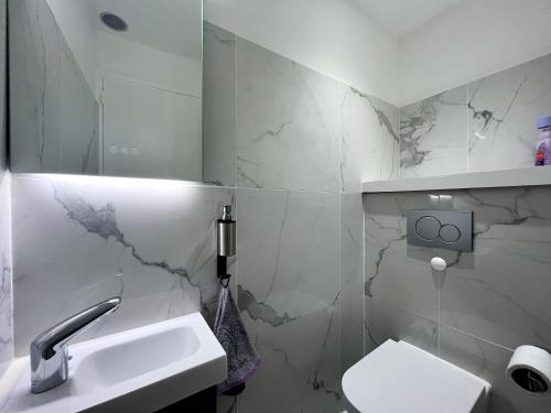 biała łazienka z umywalką i toaletą w obiekcie "Rue Longue" Vue Mer, Spacieux, Rénové w Mentonie