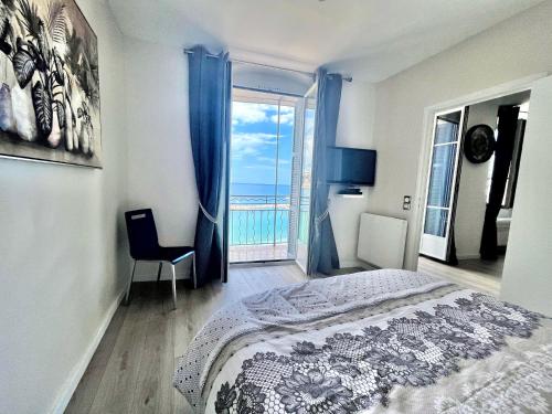a bedroom with a bed and a view of the ocean at "Rue Longue" Vue Mer, Spacieux, Rénové in Menton