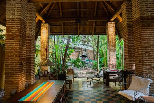 ein Wohnzimmer mit einem Holztisch in einem Backsteingebäude in der Unterkunft Casa Real Del Cabrero by Soho in Cartagena de Indias