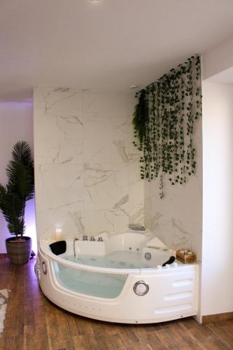 - une baignoire dans une chambre dotée d'un mur en marbre dans l'établissement Appartement cosy & balnéo - Centre de Sarlat, à Sarlat-la-Canéda