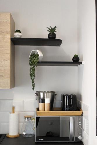 une cuisine avec un comptoir avec un micro-ondes dans l'établissement Appartement cosy & balnéo - Centre de Sarlat, à Sarlat-la-Canéda