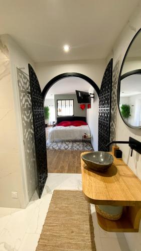 La salle de bains est pourvue d'un lavabo et d'un lit dans la chambre. dans l'établissement Appartement cosy & balnéo - Centre de Sarlat, à Sarlat-la-Canéda