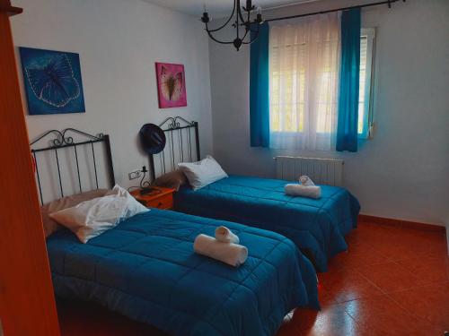 a bedroom with two beds with towels on them at Casa rural cascales in Cervera del Llano