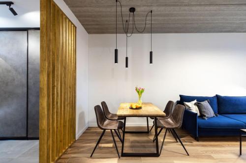 una sala da pranzo con tavolo e divano blu di City Center Sanctuary Modern Studio with Electric Car-Friendly Features in Vilnius a Vilnius