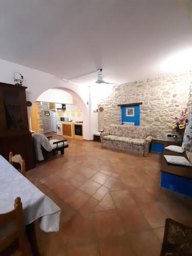 salon z kanapą i kamienną ścianą w obiekcie Casa vacanza, Vacanties Domina w mieście Fondi