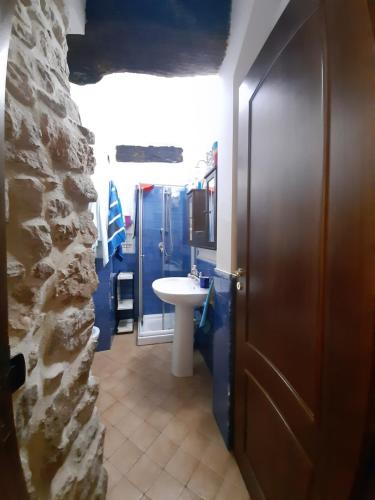 uma casa de banho com um lavatório e paredes azuis e uma porta em Casa vacanza, Vacanties Domina em Fondi