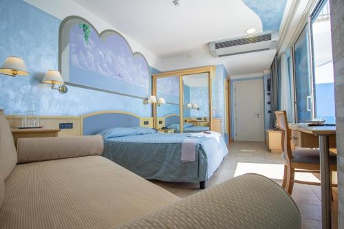 1 dormitorio con cama, mesa y escritorio en Hotel Universo, en Lido di Jesolo