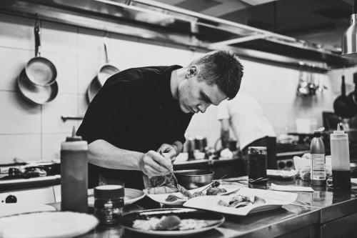 a man in a kitchen preparing food on a plate at Heritage Hotel Kukuriku in Kastav